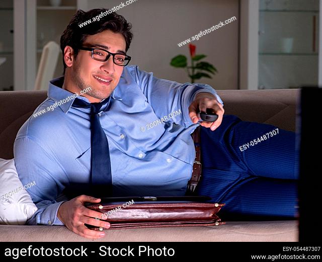 The businessman watching tv at night late
