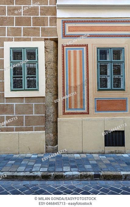 Wall and windows of historical buildings in the old town of Buda in Budapest.