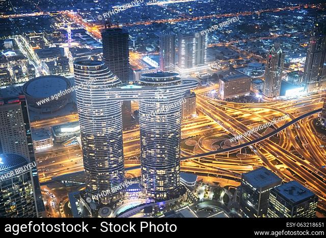 Aerial bird's-eye view of Dubai cityscape skyline. Night traffic in residential district of Dubai. Street night yellow illumination in Dubai