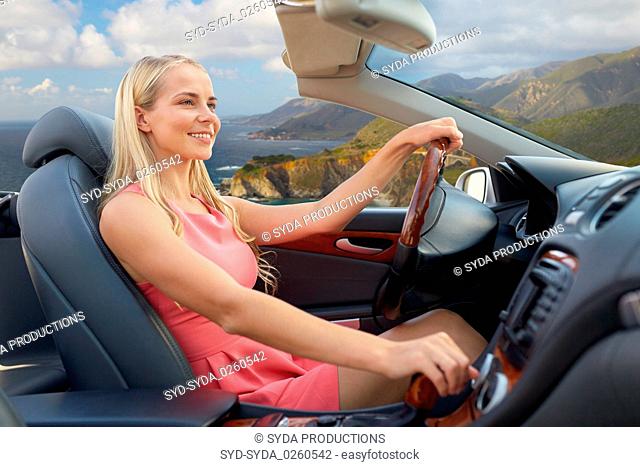 woman driving convertible car on big sur coast