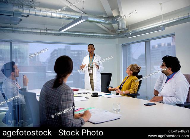 Female doctor leading conference room meeting
