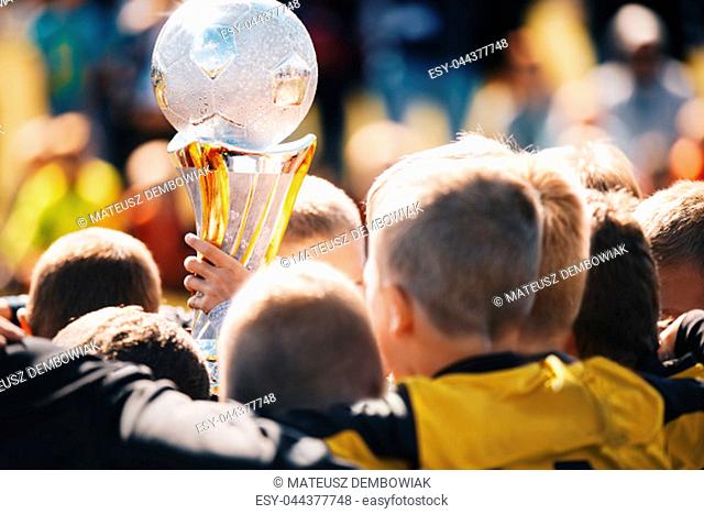 Kids Sport Team with Trophy. Kids Celebrating Football Championship. Happy Young Soccer Players Holding Golden Cup. Football Team Winning Youth Soccer...