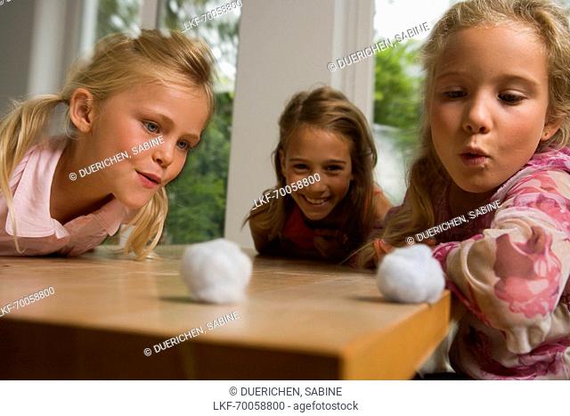 Three girls playing Blowing Cotton Wool, children's birthday party