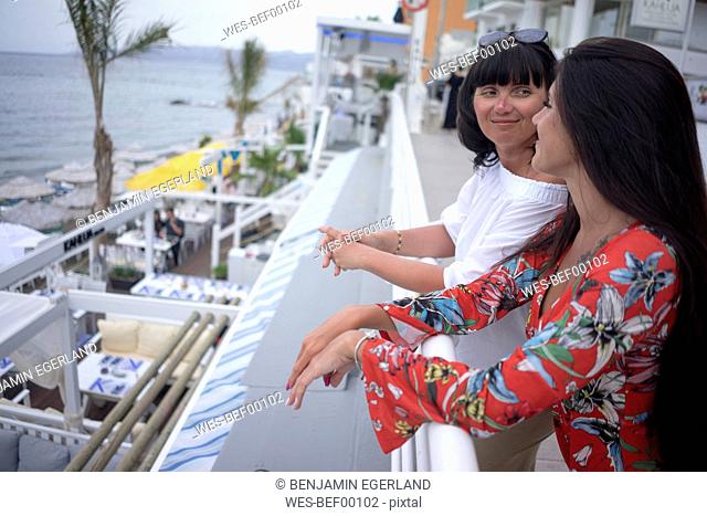 Greece, Crete, Limenas Chersonisou, mother and adult daughter relaxing on terrace