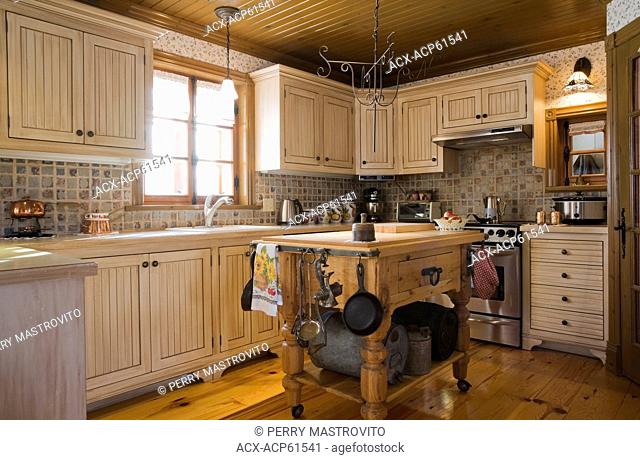 Country style kitchen inside a Canadiana cottage style fieldstone residential home built to look old in 2002, Lanaudiere, Quebec, Canada