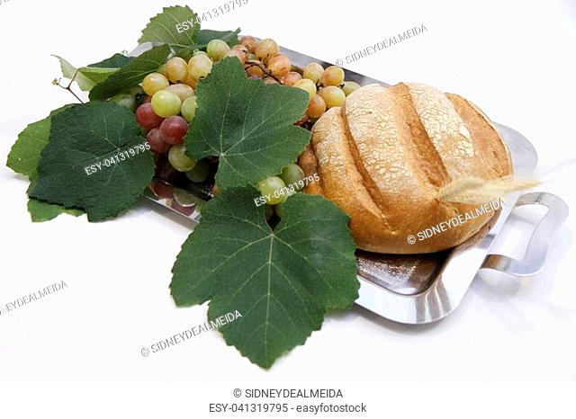Traditional bread, grapes with leaves on metal tray for offertory at Catholic Mass