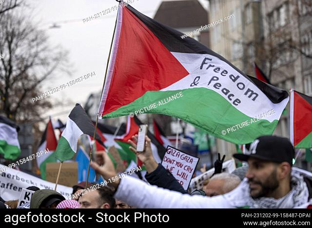 02 December 2023, North Rhine-Westphalia, Duesseldorf: A Palestinian flag with the inscription ""Freedom & Peace"" is waved at a pro-Palestine rally under the...