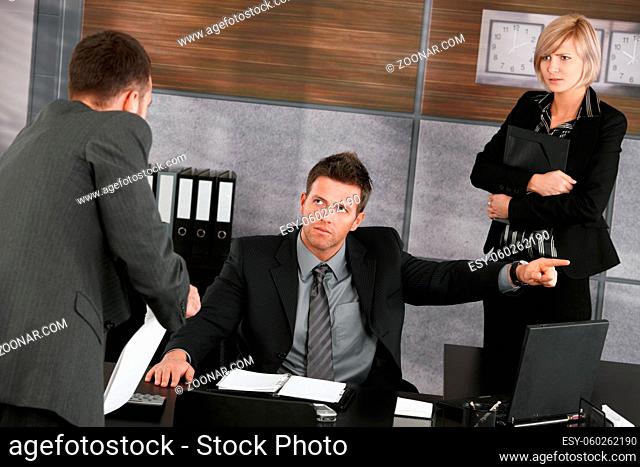 Businessman trying to explain himself to disappointed executive showing the door