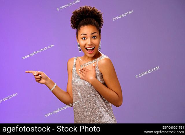 Impressed amused african-american. attractive girl glittering shiny silver dress press palm chest astonished surprised turning camera widen eyes smiling broadly...