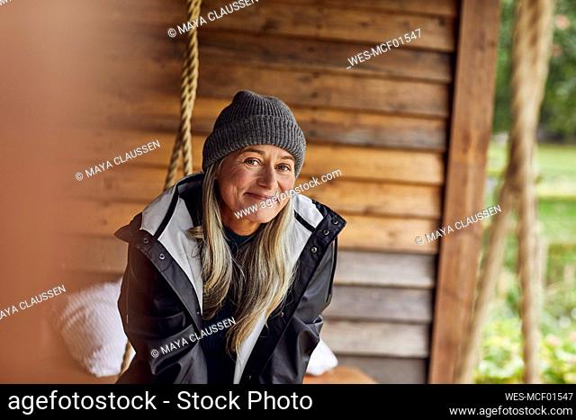 Smiling mature woman wearing knit hat in back yard