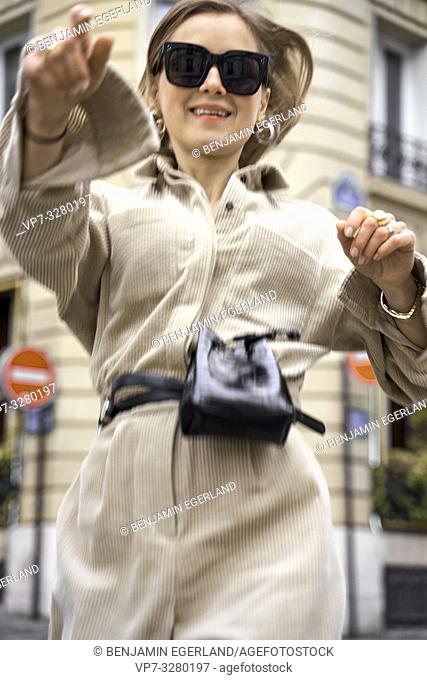 fashionable stylish woman running at street during fashion week, in Paris, France