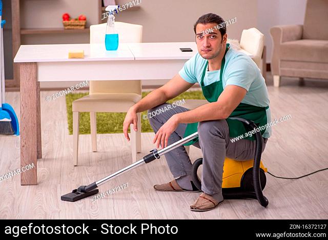 Young contractor cleaning the house