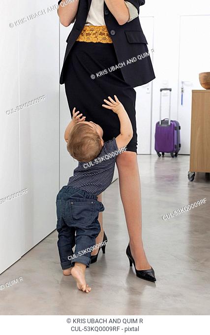Toddler boy greeting mother in hallway