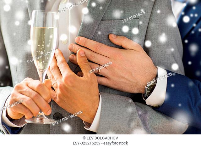 people, celebration, homosexuality, same-sex marriage and love concept - close up of happy married male gay couple in suits drinking sparkling wine from glass...