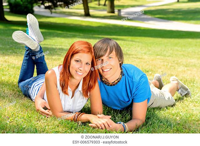 Smiling couple lying in park first love