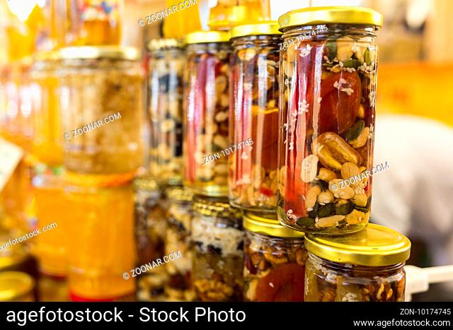 Honey with dried fruits and dried nuts - walnuts, hazelnuts, peanuts, almonds, cashews, plums, cherries, apples, figs and dates