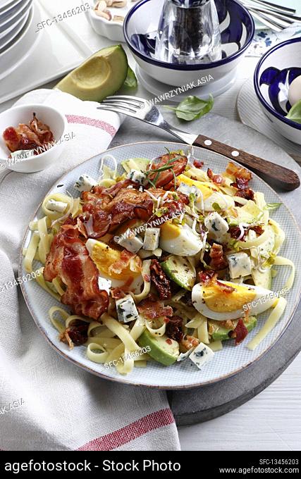 Protein salad with egg, bacon and avocado on pasta