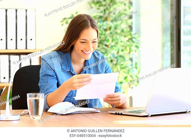 Happy entrepreneur woman reading good news in a letter in a desk at office