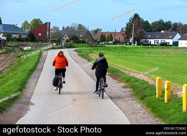 Asse, Flemish Brabant Region, Belgium - Couple driving the bike through the fields of the Flemish countryside