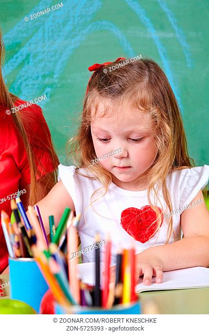 Mädchen beim Malen im Kinderzimmer mit vielen Buntstiften