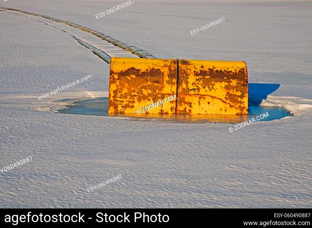 Yellow barrel in the frozen lake