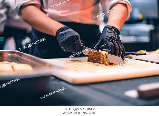 Chef at work cutting a cake in a restaurant kitchen