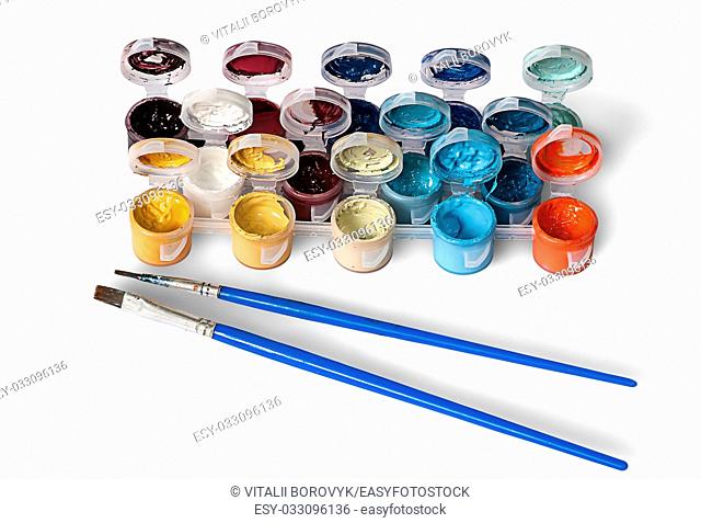 Set of colorful acrylic paints in jars and two brushes isolated on white background