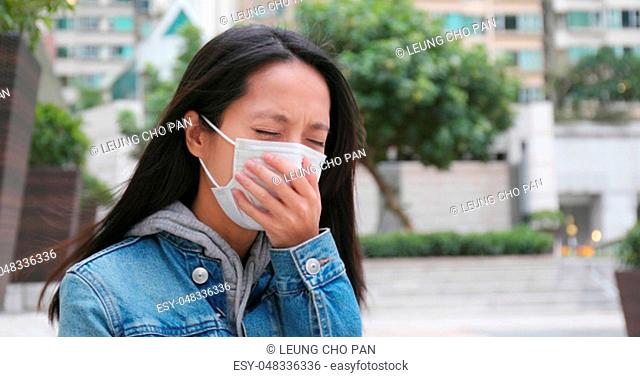 Woman coughing with wearing face mask at outdoor