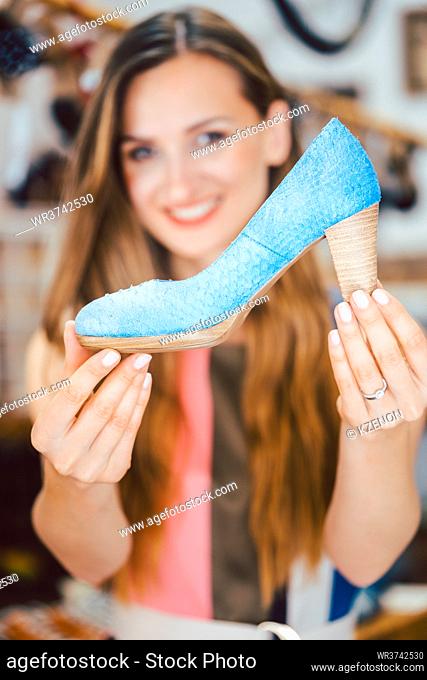 Happy woman shopping for shoes falls in love with blue high heels