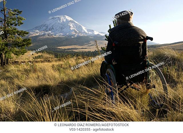 Popocatepetl volcano with a man in a wheelchair in the foreground