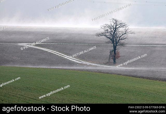 13 February 2023, Saxony, Zwönitz: A hunting lodge in a field. Plus degrees let the snow melt and evaporate to mist. Photo: Sebastian Willnow/dpa