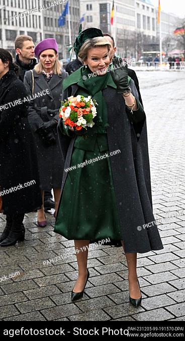 05 December 2023, Berlin: Queen Mathilde of Belgium waves to the waiting spectators on Pariser Platz near the Brandenburg Gate