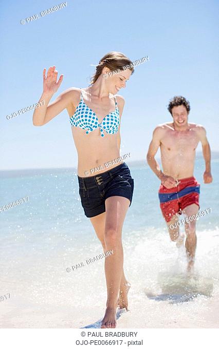 Man chasing girlfriend on beach