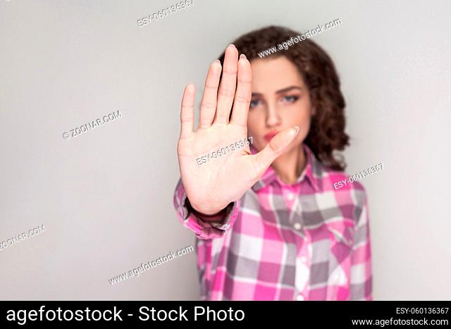Stop it. serious unhappy girl with pink checkered shirt, curly hairstyle and makeup standing, looking at camera with ban rejection or stop warning