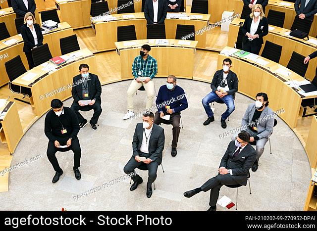 02 February 2021, Hessen, Wiesbaden: The relatives and survivors of the attack sit in the middle of the state parliament