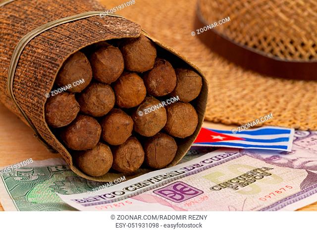 Siesta - cigars, straw hat and Cuban banknotes on a wooden table