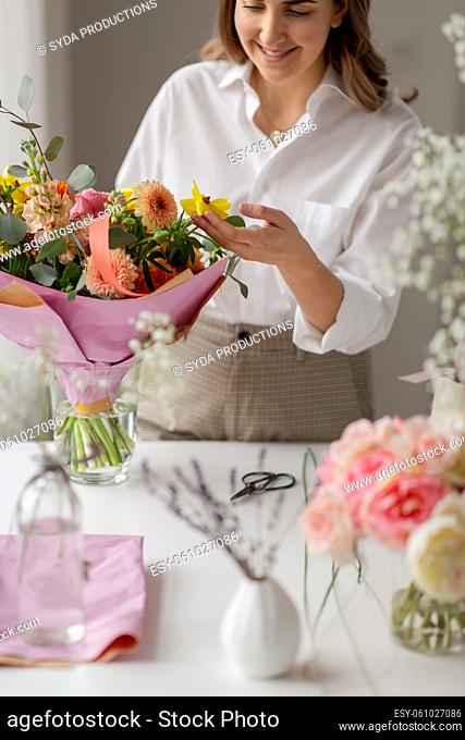 happy woman or floral artist with flowers at home