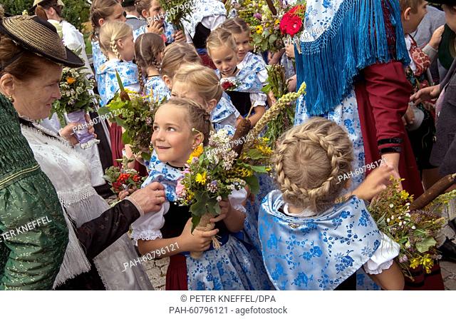 Girls wearing traditional garb carry their herb bundles to a church during the Assumption Day procession in Kochel am See, Germany, 15 August 2015