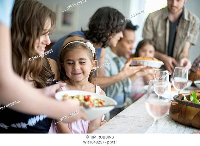 A family gathering for a meal. Adults and children around a table