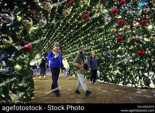 RUSSIA, SOCHI - 21 de diciembre de 2023: Los ciudadanos pasan un túnel de luces de cuerda en la calle Navaginskaya. Dmitry Feoktistov/TASS