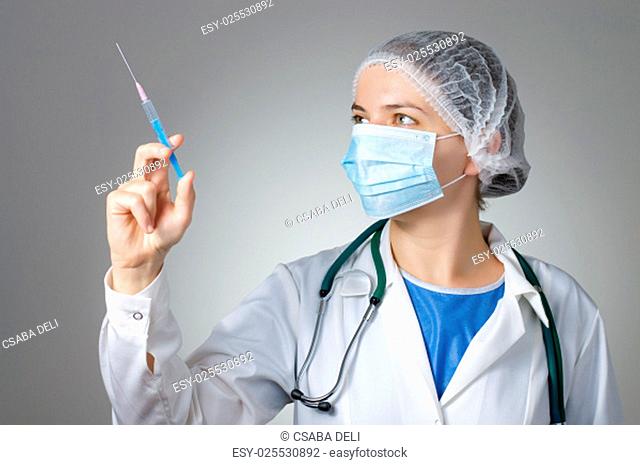 Female doctor with syringe and face mask