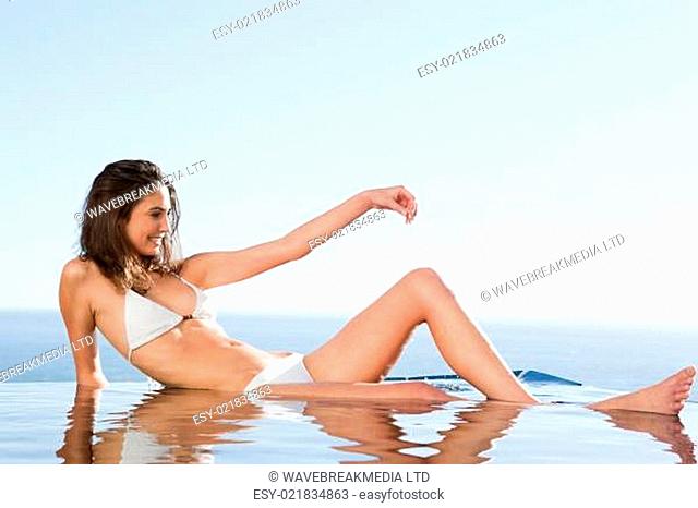 Woman sunbathing on pool edge