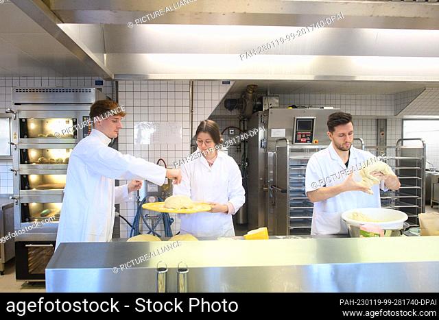 19 January 2023, Saxony-Anhalt, Bernburg: Ecotrophology students Finn Spielmann (l-r), Hannah Raudszus and Timon-Joel Strauch bake legume bread rolls in the...