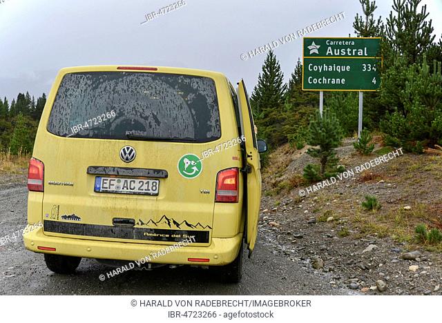 Yellow travel minibus on the Carretera Austral at Cochrane at road sign, Patagonia, Chile, South America