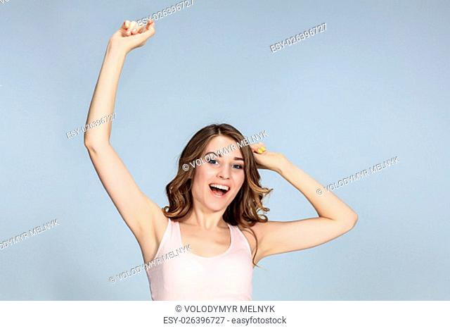 The young woman&#39;s portrait with happy emotions on gray background