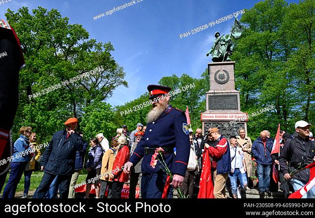 08 May 2023, Saxony, Dresden: A participant in Cossack uniform takes part in a commemoration of Liberation Day at the Red Army Memorial with the inscription...