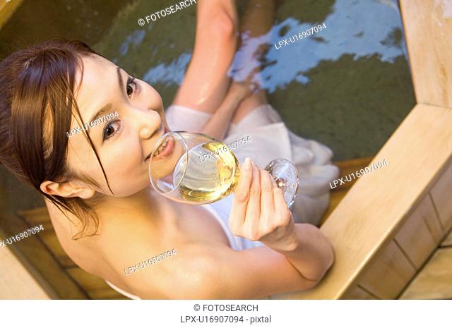 Woman enjoying a glass of wine in a hot tub