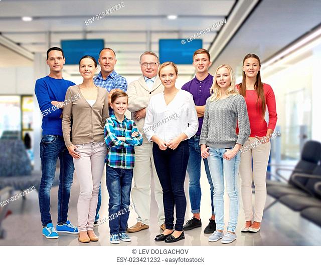 family, travel, tourism, generation and people concept - group of smiling men and women over airport waiting room background