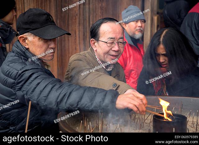 Nara, Japan - December 28, 2014: Devotees lightening incense sticks at Todai-Ji temple