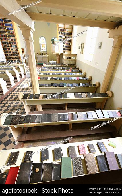 08 April 2022, Saxony-Anhalt, Luso: In the hymnal church, around 2000 collected hymnals lie on the pews and on wooden shelves